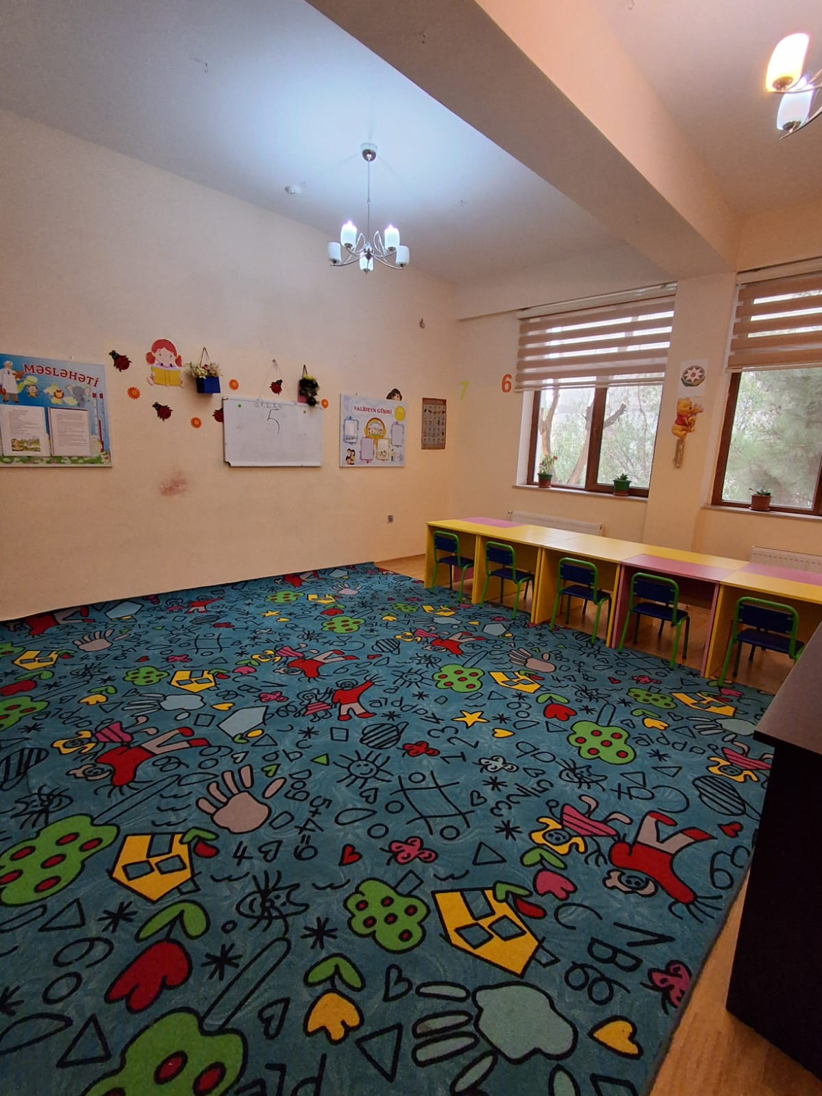 Pöhrə uşaq bağçasının oyun və dərs otaqları interyeri - rəngli oyuncaqlar, konstruktiv oyuncaq küncü və kitab rəfləri